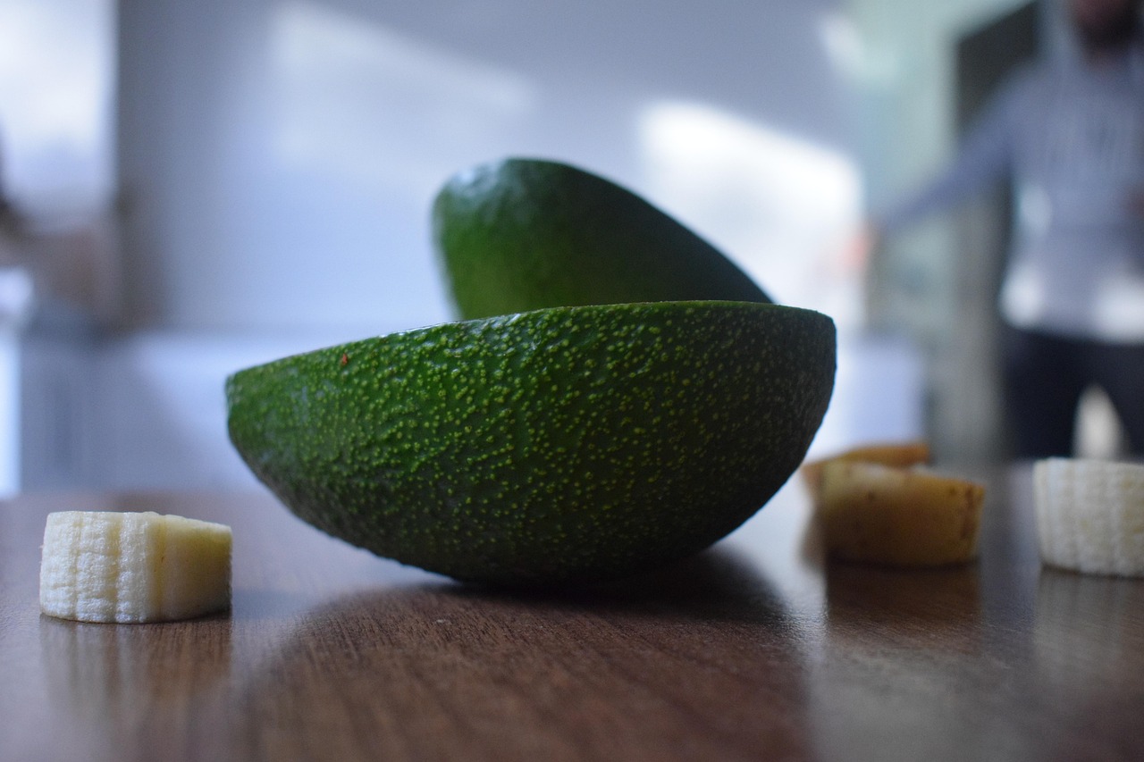 Nocciolo di avocado con stuzzicadenti immerso in un bicchiere d'acqua per germogliare.