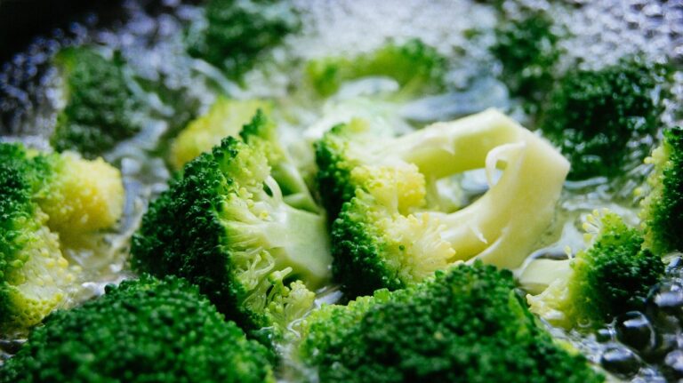 Broccoli in cottura con una fetta di pane imbevuta di aceto sul coperchio per ridurre odori.